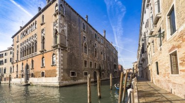 Located in the centre of the city, the building, canal, city, facade, historic site, medieval architecture, sky, tourist attraction, town, waterway, orange
