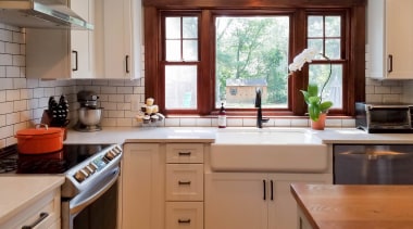 A substantial sink sits below a set of cabinetry, countertop, cuisine classique, floor, flooring, hardwood, home, interior design, kitchen, real estate, room, window, brown