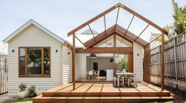 A large outdoor space transitions to the lawn backyard, cottage, deck, estate, facade, home, house, outdoor structure, property, real estate, roof, white, brown