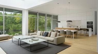 An expansive lounge feels even larger thanks to floor, flooring, furniture, hardwood, house, interior design, laminate flooring, living room, table, wood flooring, gray