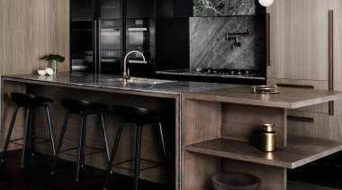 This island is perfect for an apartment, featuring cabinetry, countertop, floor, flooring, furniture, interior design, kitchen, sink, table, black, gray