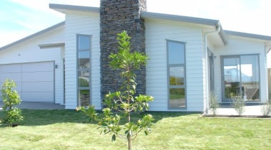 This contemporary home has a stone feature chimney cottage, estate, facade, grass, home, house, land lot, property, real estate, siding, window, yard, white, yellow