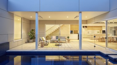The serene pool sits alongside a sheltered outdoor apartment, architecture, condominium, estate, home, house, interior design, leisure centre, property, real estate, orange