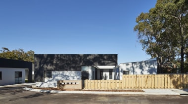 The tree line rises up above the development architecture, building, cottage, facade, home, house, property, real estate, residential area, teal
