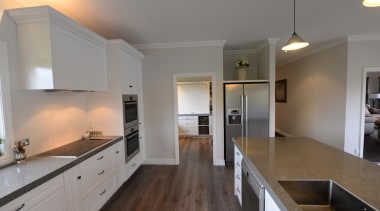 Country styled island kitchen in this Taranaki home cabinetry, countertop, floor, flooring, hardwood, home, interior design, kitchen, laminate flooring, property, real estate, room, wood, wood flooring, gray