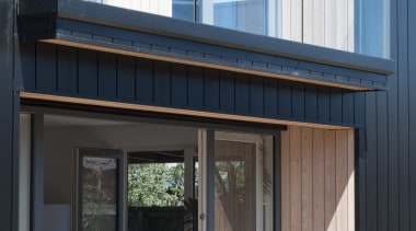 This exterior view of the home features the architecture, door, facade, house, siding, window, black