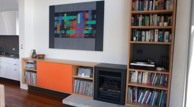 The new gas fireplace integrates seemlessly with the bookcase, furniture, interior design, library, living room, shelf, shelving, gray