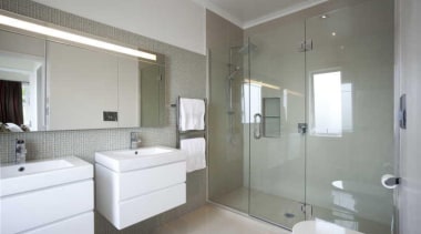 Bathroom with white vanities and glassed in shower. bathroom, bathroom accessory, floor, home, interior design, property, real estate, room, wall, gray