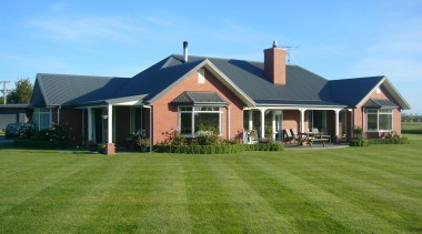 A Canterbury kiln fired red brick home of backyard, cottage, elevation, estate, facade, farmhouse, grass, home, house, land lot, landscape, landscaping, lawn, property, real estate, residential area, roof, siding, sky, window, yard, teal, green