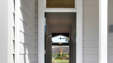 The main entry provides lines of sight through architecture, door, estate, home, house, structure, window, gray, white