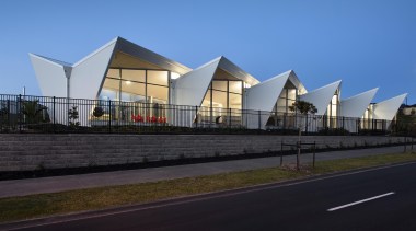 Road side view showing end treatment of repetitive architecture, building, commercial building, corporate headquarters, facade, house, mixed use, real estate, residential area, sky, structure, black, teal