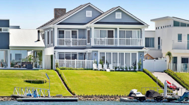 At the rear of this Hampton's style home, apartment, architecture, boating, building, estate, home, house, leisure, mansion, property, real estate, residential area, roof, vacation, vehicle, villa, water transportation, waterway, teal