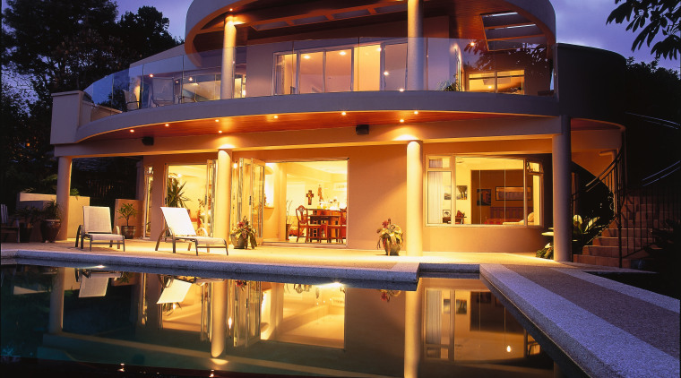 Exterior of house looking over pool back to architecture, estate, evening, home, house, landscape lighting, lighting, property, real estate, reflection, swimming pool, villa, black