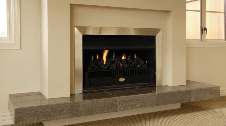 Indoor fireplace with cream and aluminium surround, and fireplace, hearth, heat, wood burning stove, orange, brown