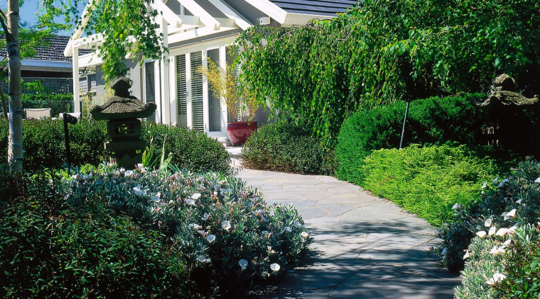 Landscape renovation. Leafy foliage line the slate path backyard, cottage, estate, garden, grass, home, house, landscape, landscaping, lawn, leaf, outdoor structure, plant, real estate, residential area, shrub, tree, walkway, yard, green