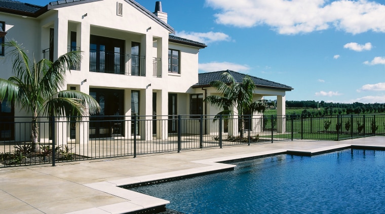 View of the outdoor living area of this condominium, elevation, estate, home, house, mansion, property, real estate, residential area, resort, sky, swimming pool, villa, water, white, blue