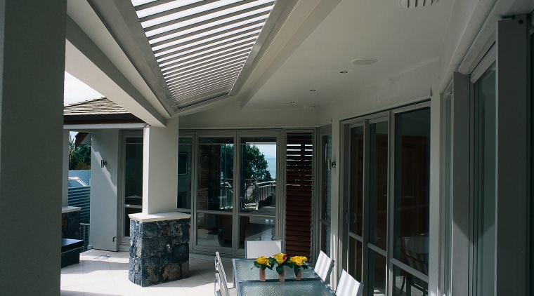 An outdoor sitting area featuring an aluminium opening ceiling, daylighting, interior design, real estate, roof, window, gray, black