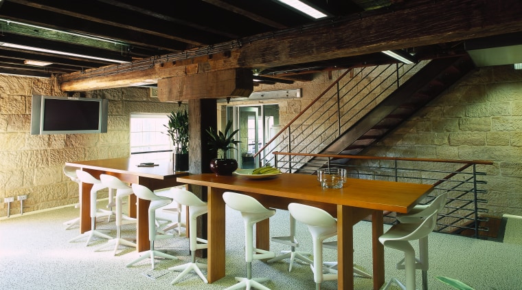 Long timber table in hospitality area with white architecture, furniture, interior design, table, wood, black