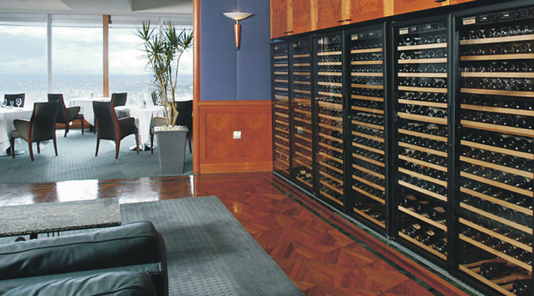 Wine storage cabinets along wall with seating area, floor, flooring, furniture, interior design, wood, black