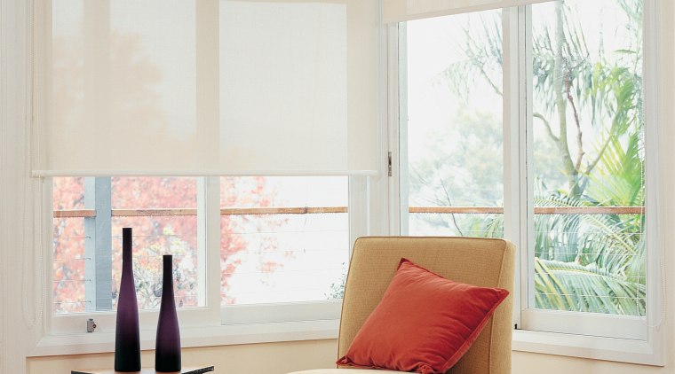 Lounge area with tan coloured chair and stool, bed frame, ceiling, couch, curtain, floor, flooring, furniture, hardwood, home, interior design, living room, room, shade, window, window blind, window covering, window treatment, wood, wood flooring, gray