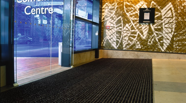 Entranceway of convention through glass doors with striped flooring, black