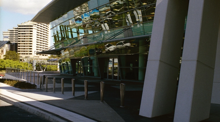 Exterior view of section of building showing sloping architecture, building, corporate headquarters, facade, metropolitan area, reflection, sky, structure, black