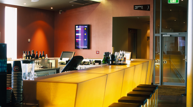 Bar area of cinema complex with yellow bar interior design, lighting, restaurant, table, brown