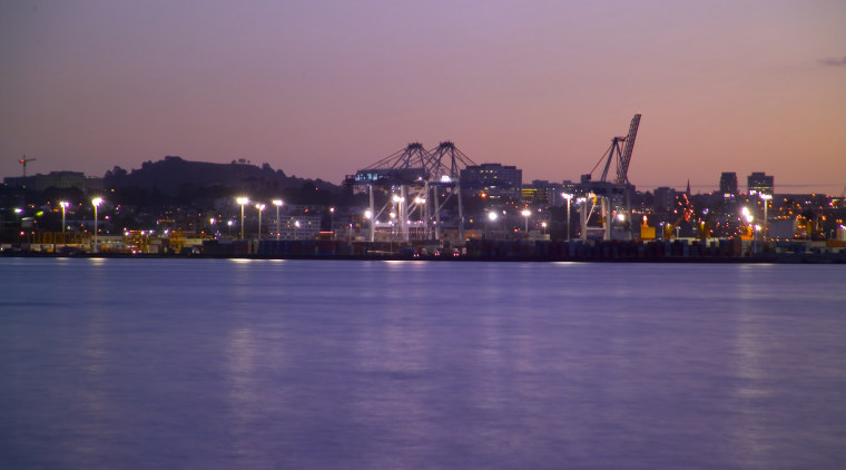 Distant view of Port of Auckland complex, showing body of water, calm, city, cityscape, dawn, downtown, dusk, evening, horizon, night, reflection, river, sea, sky, skyline, sunset, water, waterway, purple