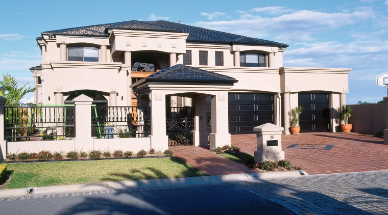 An overall view of a house, cream plastered building, elevation, estate, facade, home, house, mansion, property, real estate, residential area, roof, sky, suburb, villa, teal