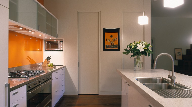A view of a kitchen, wooden flooring, white cabinetry, countertop, interior design, kitchen, real estate, room, brown, gray