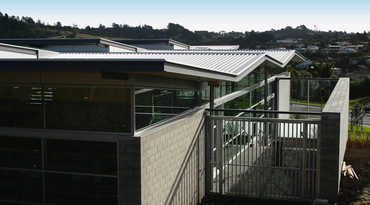 Exterior view of building with brick cladding, windows facade, fence, home, house, property, real estate, residential area, roof, shed, black