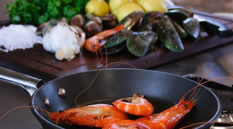 Stainless steel benchtop with gas cooktop, frypan with cookware and bakeware, cuisine, dish, food, meal, black