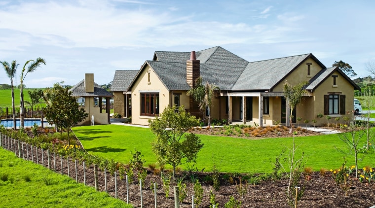 view of the house featuring plastered and lime cottage, estate, facade, farm, farmhouse, fence, field, grass, home, house, land lot, landscape, landscaping, lawn, outdoor structure, plantation, property, real estate, residential area, roof, rural area, sky, tree, yard, white