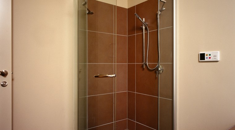 Frameless shower unit with brown wall and floor bathroom, door, floor, glass, plumbing fixture, room, shower, brown, orange