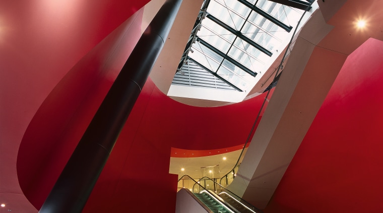 Escalator area with large red conical drum surround angle, architecture, ceiling, daylighting, design, interior design, line, red, structure, red