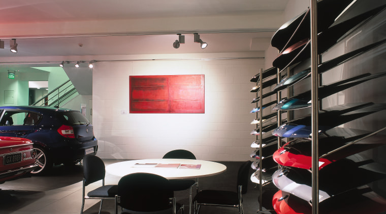 BMW showroom with white walls, shelving for parts ceiling, interior design, gray, black