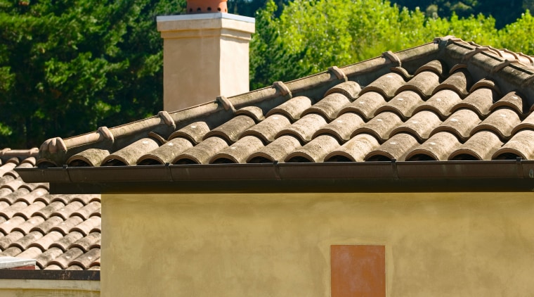 View of masonry home with clay roofing tiles. chimney, estate, facade, home, house, outdoor structure, real estate, roof, window, brown, orange