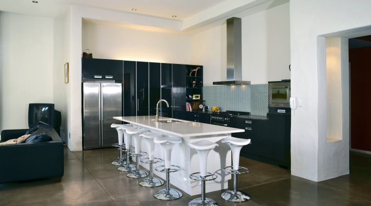 Open plan kitchen with black cabinetry and white ceiling, countertop, floor, flooring, interior design, kitchen, real estate, room, tile, wood flooring, gray