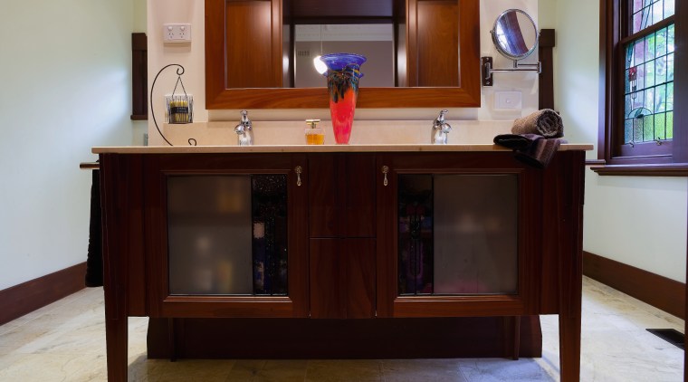 view of the bathroom featuring dante solid timber cabinetry, chest of drawers, desk, flooring, furniture, hardwood, table, wood stain, gray