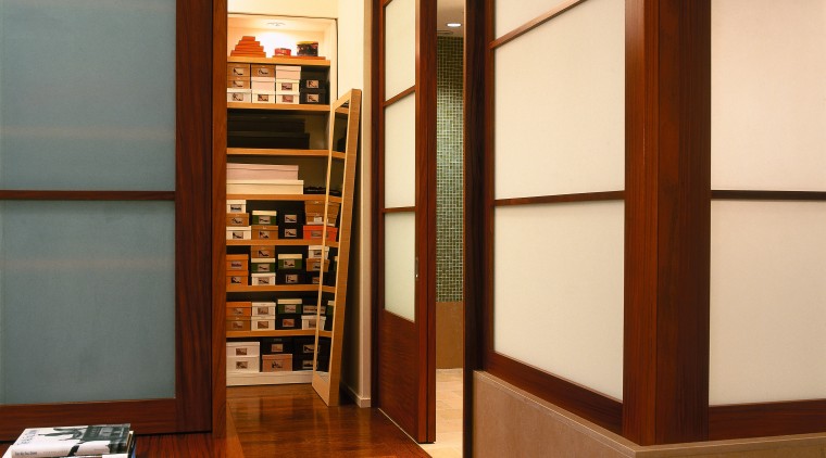 view of this master bedroom leading to the bookcase, cabinetry, door, floor, flooring, furniture, interior design, shelf, shelving, brown, orange