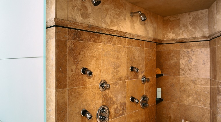 view of this bathrom featuring a noritz tankless bathroom, ceiling, floor, flooring, interior design, plumbing fixture, room, shower, tile, wall, brown