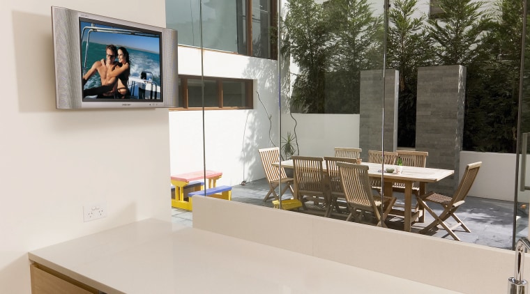 Kitchen with white benchtop, wall mounted tv screen, countertop, furniture, interior design, product design, table, white