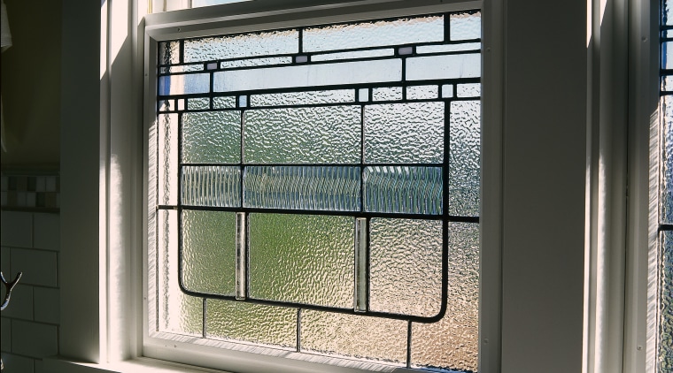 view of this bathroom featuring freestanding kohler bathtub, daylighting, glass, window, black, white