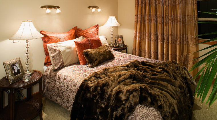 Bedroom with patterned bedding, cushions and throw, small bed, bed frame, bed sheet, bedding, bedroom, duvet cover, furniture, home, interior design, linens, room, suite, textile, window, brown