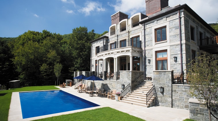 Exterior view of the house contsructed from granite building, cottage, estate, facade, home, house, mansion, property, real estate, swimming pool, villa, white