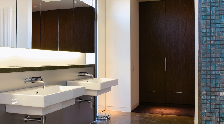 Large wall-hung basins accentuate the size of the architecture, bathroom, cabinetry, ceiling, countertop, daylighting, floor, flooring, interior design, real estate, room, sink, tile, wood flooring, gray, brown