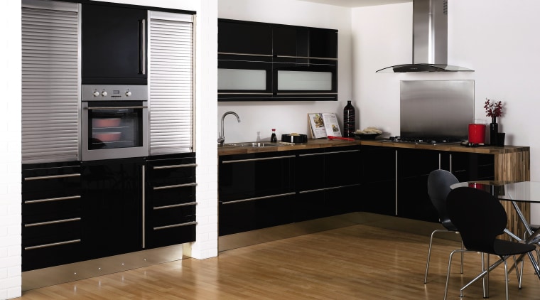 View of this modern kitchen featuring Stainless steel cabinetry, countertop, floor, flooring, furniture, home appliance, interior design, kitchen, white, black