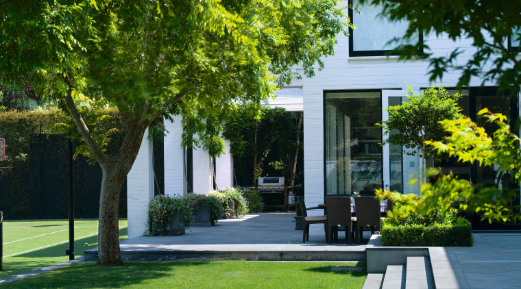 A view of the outdoor entertaining area featuring architecture, courtyard, estate, facade, garden, grass, home, house, landscape, landscaping, lawn, neighbourhood, outdoor structure, plant, property, real estate, residential area, tree, walkway, yard, green
