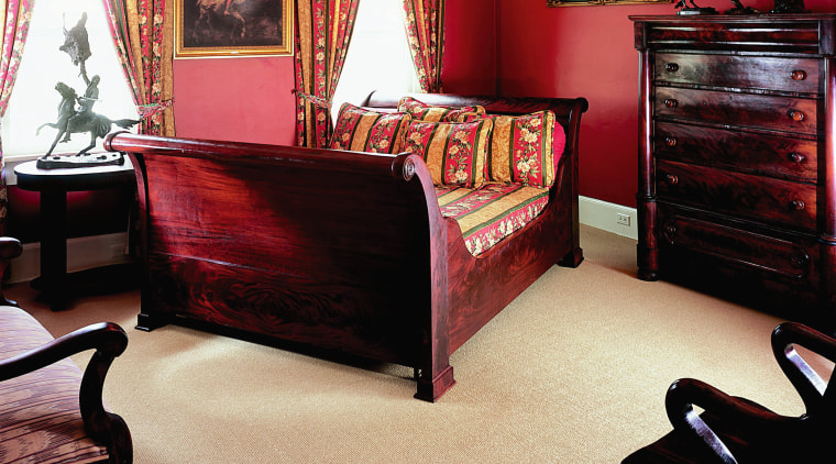 View of bedroom with red walls, red toned bed, bed frame, bedroom, ceiling, floor, flooring, furniture, hardwood, home, interior design, laminate flooring, living room, room, suite, table, wall, window, wood, wood flooring, orange