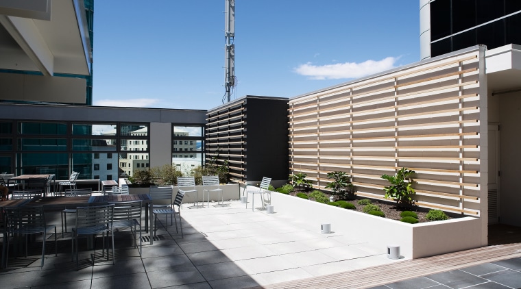 View of the outdoor cafe featuring planter boxes, apartment, architecture, building, commercial building, condominium, corporate headquarters, daylighting, facade, headquarters, mixed use, real estate, residential area, urban design, black